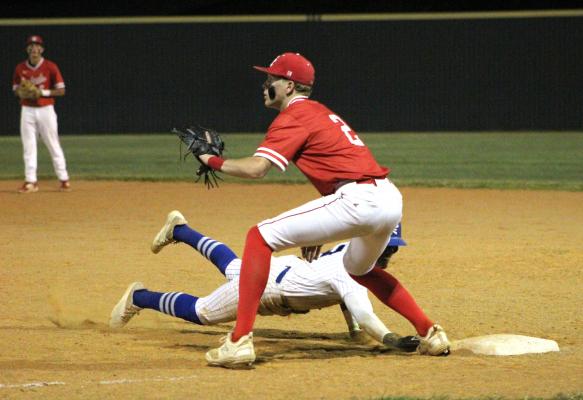 Edna's Braylen Harris dives safely back to first as the Columbus first baseman awaits the pickoff attempt.